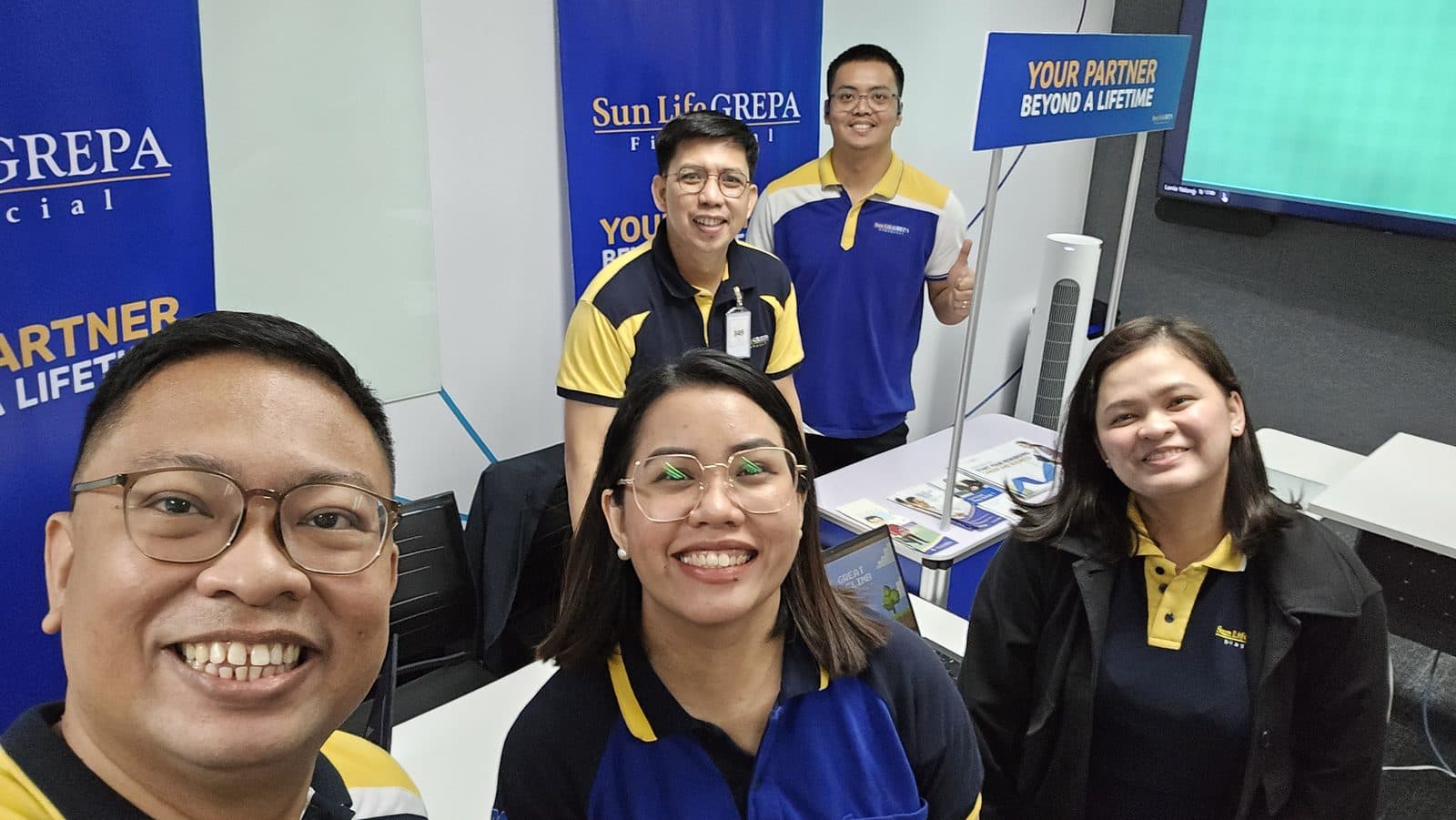 Kuya Aries and colleagues at a Sun Life Grepa client booth